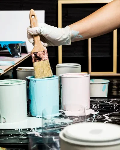 Brocha mojándose en bote de pintura durante la preparación de colores